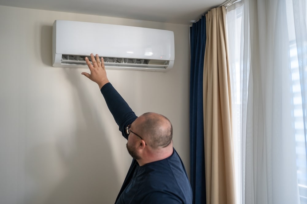 Photo of a man with AC remote in hand