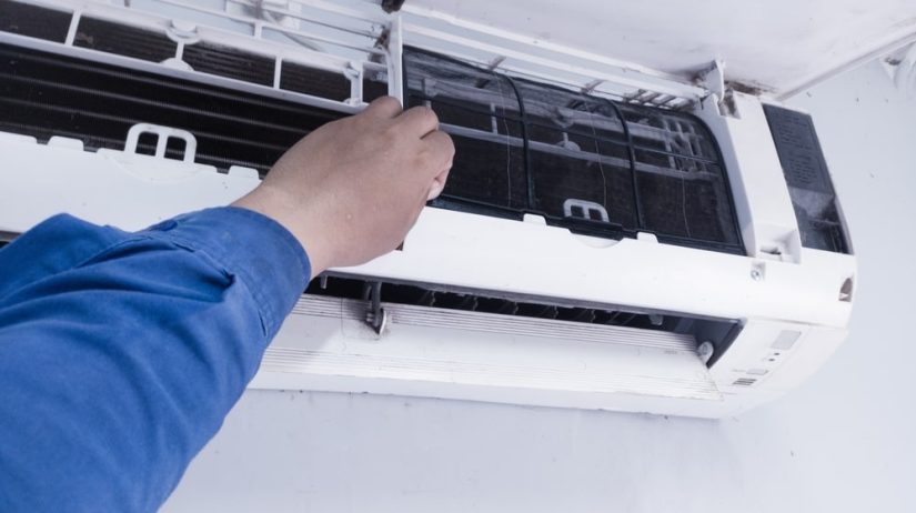 Photo of Air Conditioning cleaning process with man changing filters