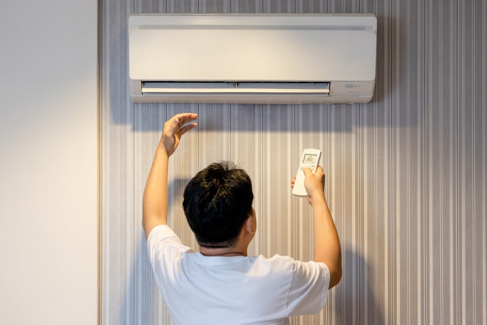 Man Turning On An AC Unit