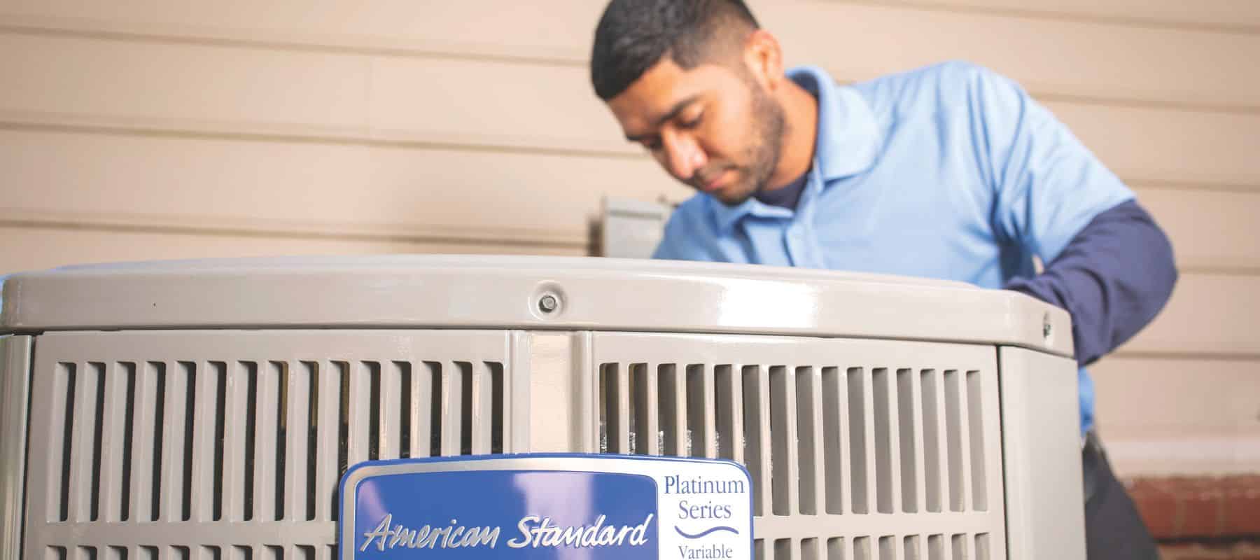 HVAC technician working on an American Standard Platinum Series air conditioning unit