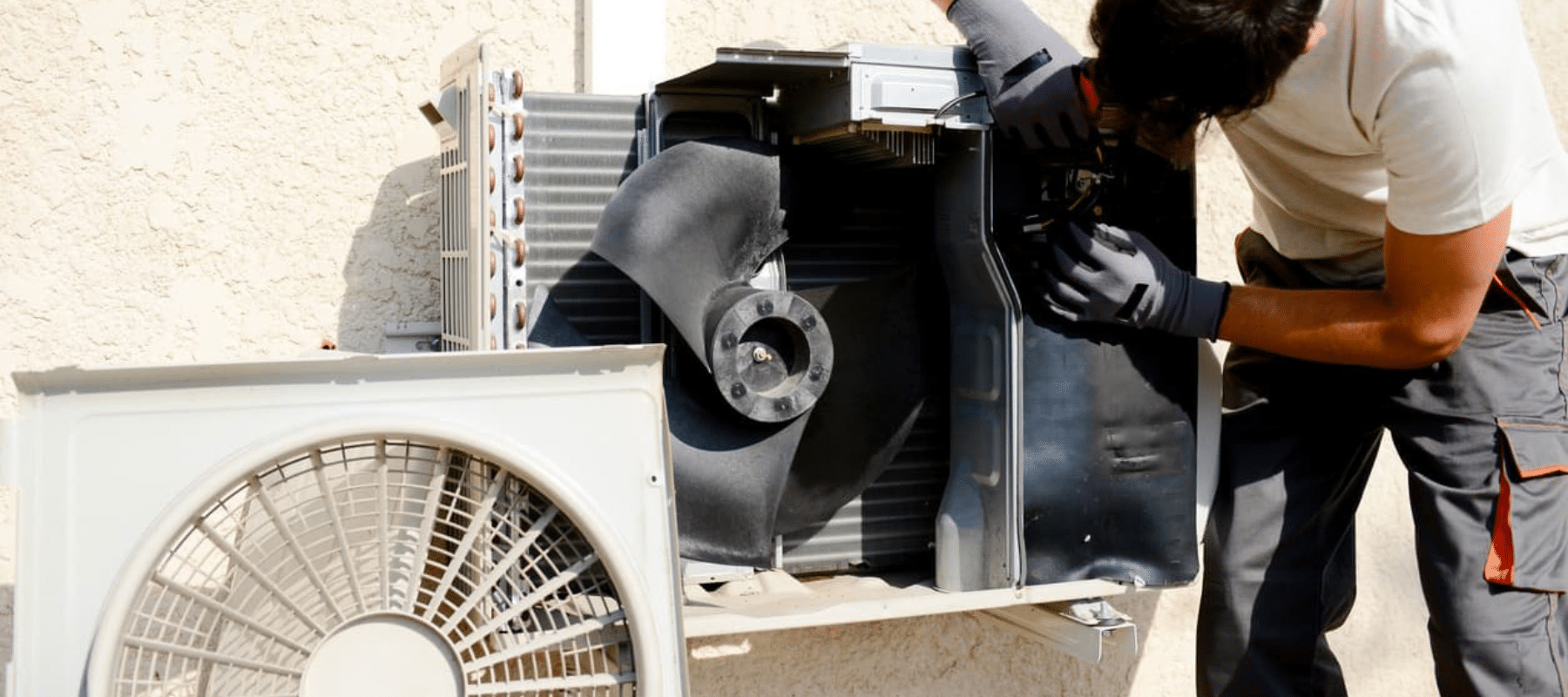 A technician repairing the internal components of an outdoor air conditioning unit